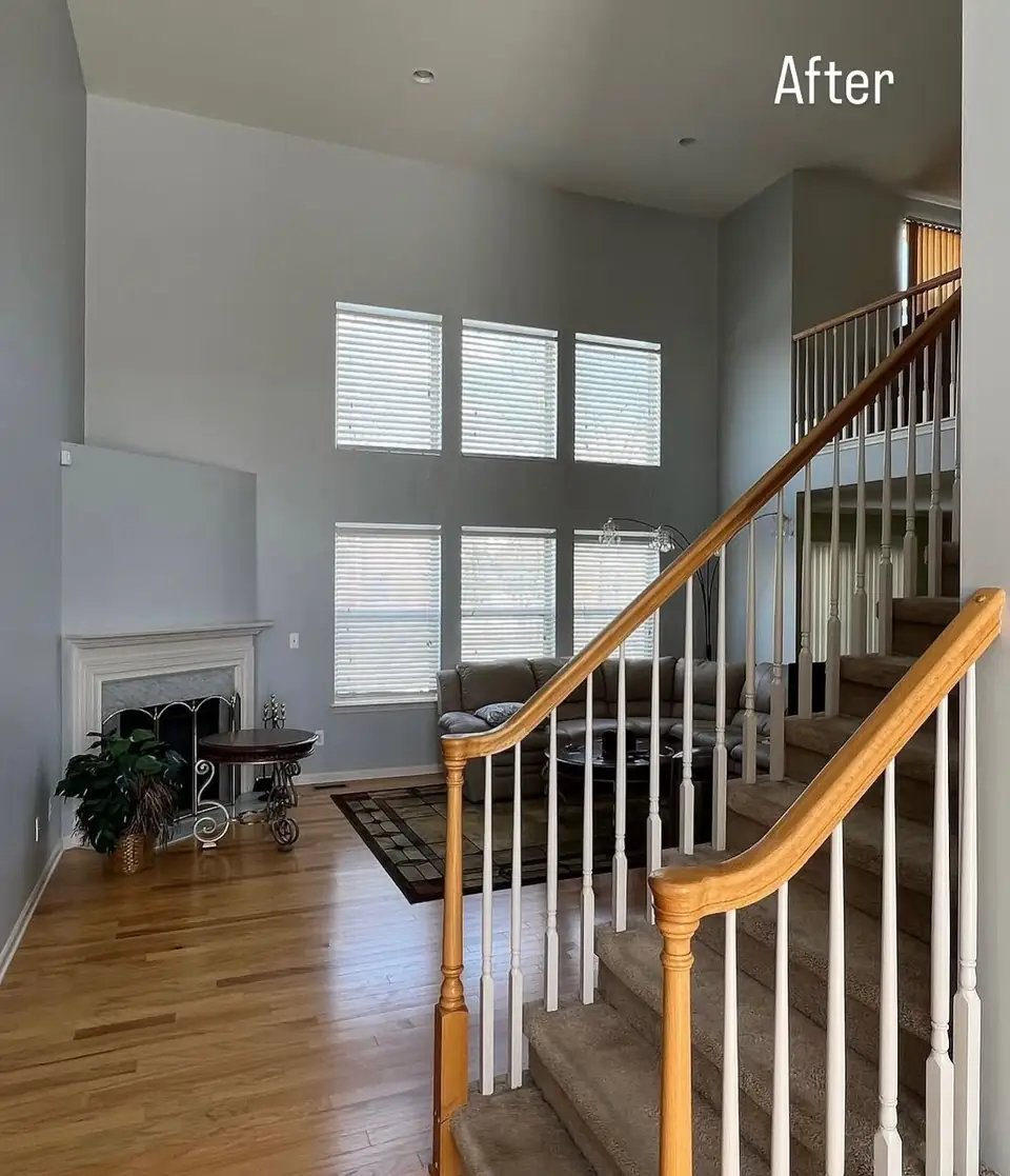 Two-story great room with fresh neutral walls and white-painted staircase spindles