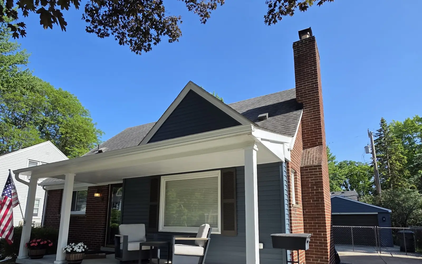 Navy bungalow with white porch columns freshly painted by Crist Painting